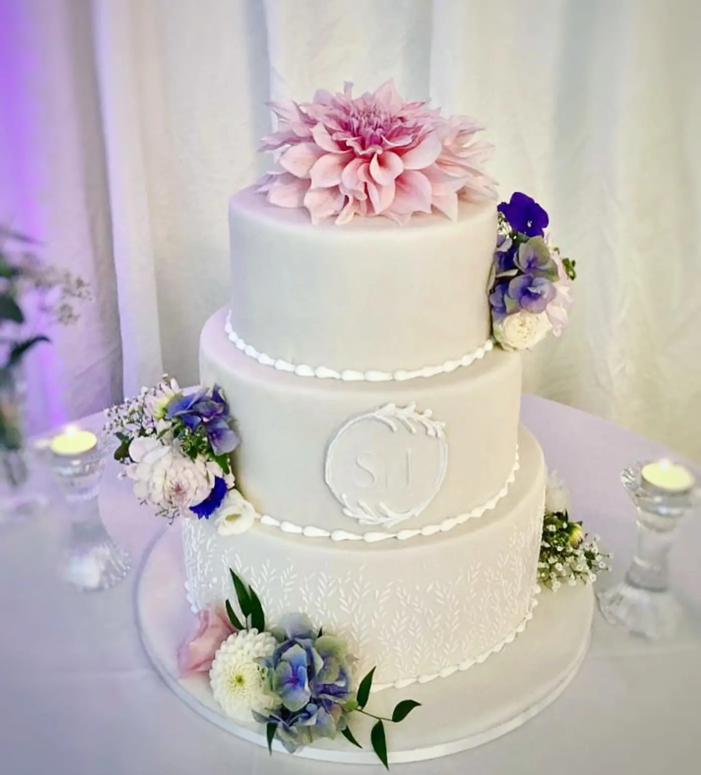 Three-tier celebration cake decorated with fresh flowers