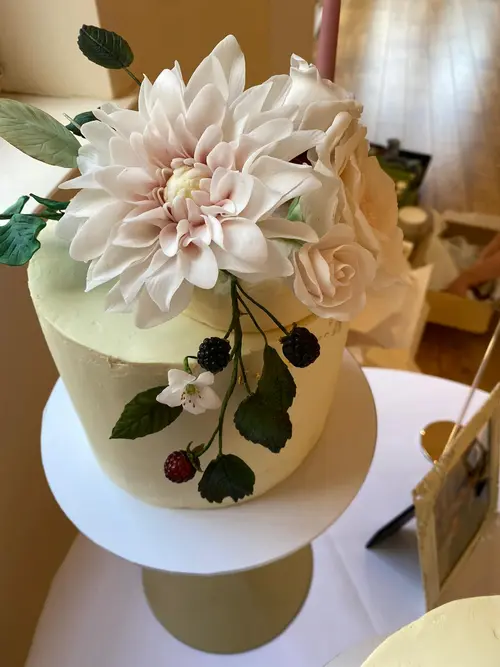 White celebration cake with dahlia flower decoration